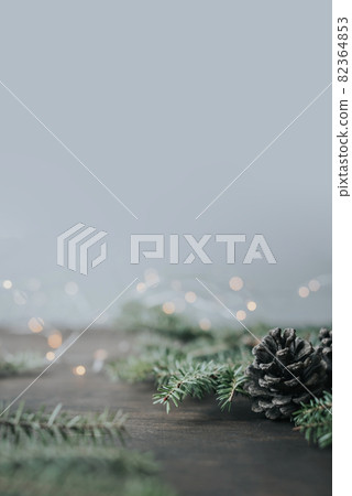 Minimalistic winter christmas background. Fir branches and cones on a wooden table. 82364853