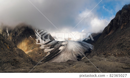 Panoramic view of the Big Aktru Glacier, high in the mountains, covered by snow and ice. Dramatic Altai winter landscape. Panoramic view of the Big Aktru Glacier, high in the mountains, covered by snow and ice. Dramatic Altai winter landscape. 82365027