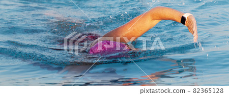 Close up of women swimming in a pool with a pink bathing cap Close up of women swimming in a pool with a pink bathing cap 82365128
