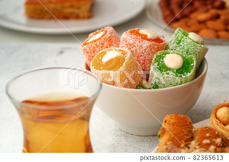 Various Turkish sweets and cup of tea on white textured background 82365613