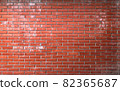 Red brick wall background. Brickwork texture with scratches and cracks. Traces of white paint, cement, and concrete on wall. Photo of facade of old building. Can be used as background or wallpaper 82365687