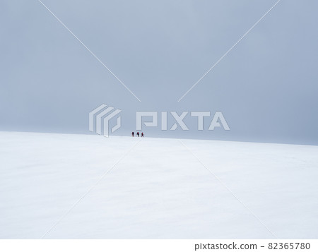 come to top of misty snowy hill. teamwork and victory, teamwork of people in difficult conditions. Difficult climb to the top of the mountain. come to top of misty snowy hill. teamwork and victory, teamwork of people in difficult conditions. Difficult climb to the top of the mountain. 82365780