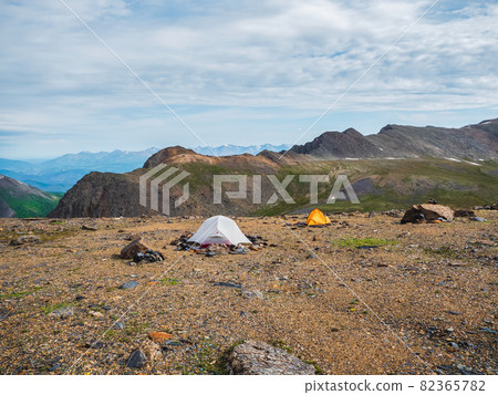 Camping on a rocky high-altitude plateau. Two tents on the background of high mountains. Camping on a rocky high-altitude plateau. Two tents on the background of high mountains. 82365782
