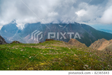 Clouds descend on the valley from the mountains. Atmospheric large snow mountain tops in cloudy sky. Clouds descend on the valley from the mountains. Atmospheric large snow mountain tops in cloudy sky. 82365843