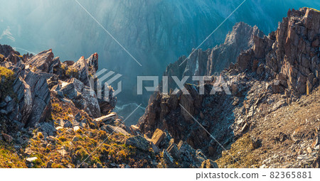 Panoramic view of dangerous couloir. Colorful sunny landscape with cliff and big rocky mountains and epic deep gorge. Panoramic view of dangerous couloir. Colorful sunny landscape with cliff and big rocky mountains and epic deep gorge. 82365881
