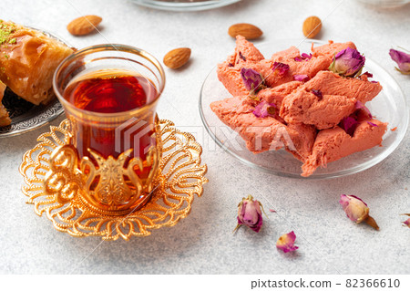 Assortment of Turkish delights with glass of tea on gray background 82366610