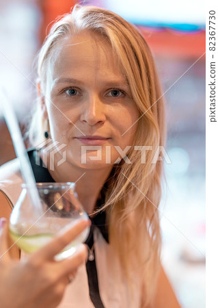 Woman enjoying time at cocktail party Woman enjoying time at cocktail party 82367730