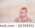 Newborn child wearing a diaper in white sunny bedroom. Newborn child relaxing in bed. Beautiful girl lies a happy smile, great design for any purposes. Happy family. Funny girl 82368502