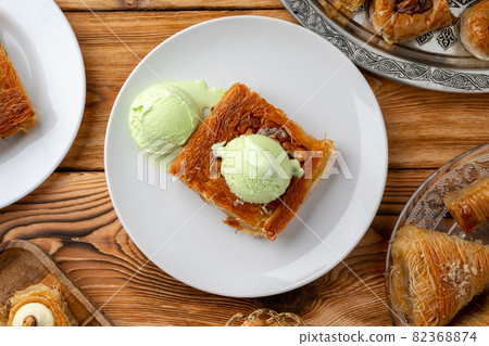 Turkish dessert kunefe served with ice cream on wooden background 82368874