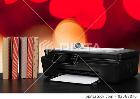 Stack of books and home printer against blurred background 82368876