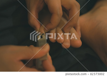 Mother cutting a child's toenails Mother cutting a child's toenails 82373802