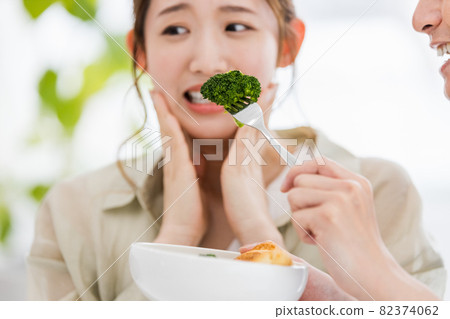 Young woman tired of eating broccoli Young woman tired of eating broccoli 82374062
