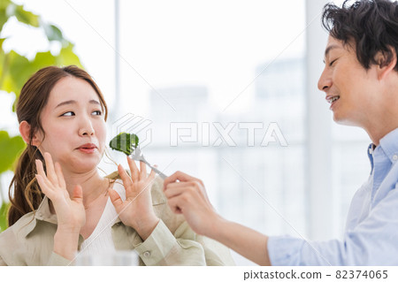 Young woman tired of eating broccoli Young woman tired of eating broccoli 82374065