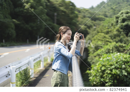 A woman taking a walk with a camera 82374941