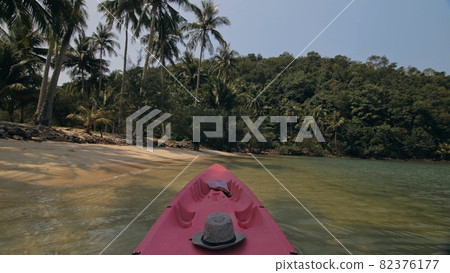 Yellow paddle on pink canoe standing on sand beach Yellow paddle on pink canoe standing on sand beach 82376177