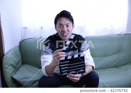 Japanese man with clapperboard 82376792