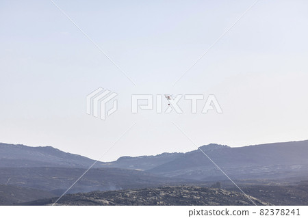 Helicopters over a landscape burned by a forest fire, finishing putting it out 82378241