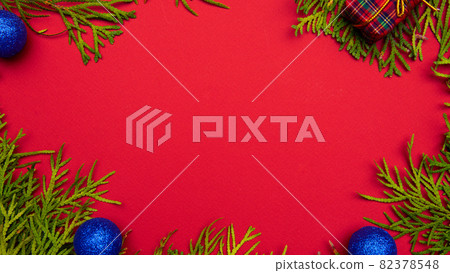 Christmas or New Year red background, framed by a Christmas tree, seasonal decorations, space for text, top view Christmas or New Year red background, framed by a Christmas tree, seasonal decorations, space for text, top view 82378548