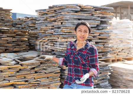 Hispanic woman worker posing with natural stone tile 82378628
