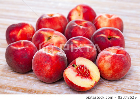 Closeup of whole ripe red peaches on wooden table. 82378629