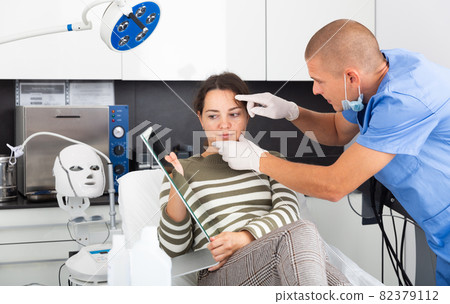 Beautician examining female face skin after procedure 82379112