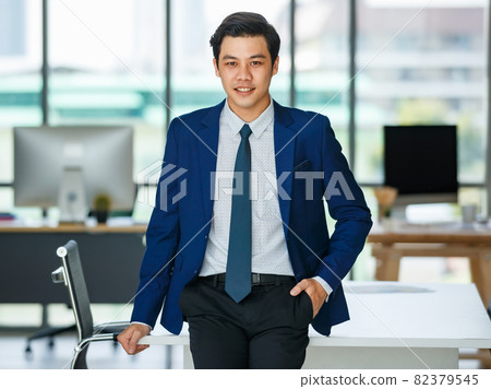 Stylish male entrepreneur standing in office Stylish male entrepreneur standing in office 82379545