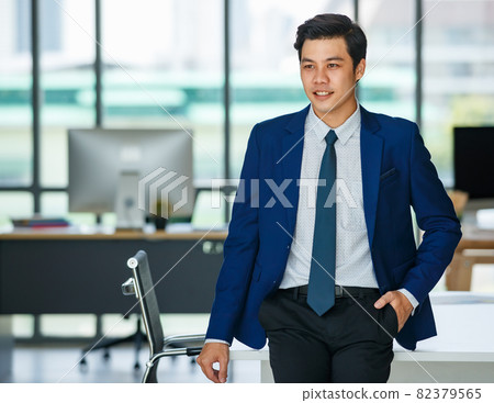 Stylish male entrepreneur standing in office Stylish male entrepreneur standing in office 82379565