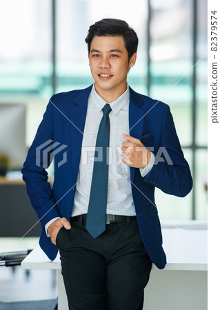 Stylish male entrepreneur standing in office Stylish male entrepreneur standing in office 82379574