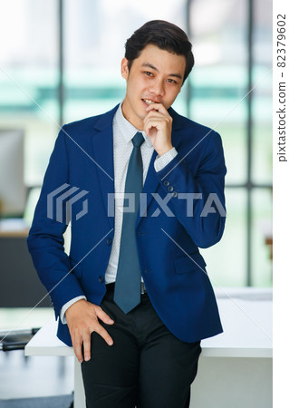Stylish male entrepreneur standing in office Stylish male entrepreneur standing in office 82379602