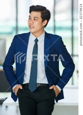 Stylish male entrepreneur standing in office Stylish male entrepreneur standing in office 82379614