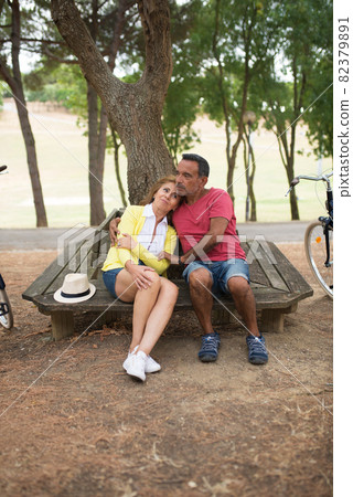 Portrait of happy mature couple resting on bench Portrait of happy mature couple resting on bench 82379891