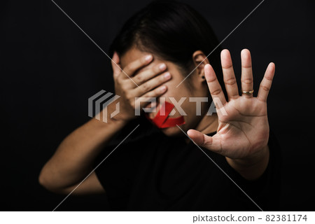 Woman wrapping mouth with tape and show hand sign stop abusing violence 82381174