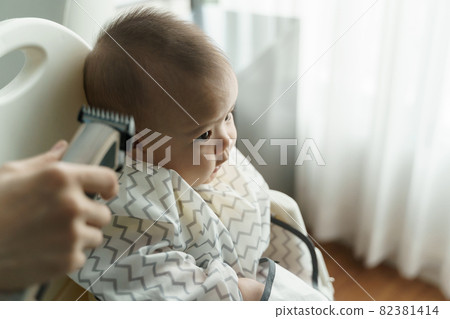 Asian little Baby boy is cutting hair by his mother with hair clipper at home 82381414