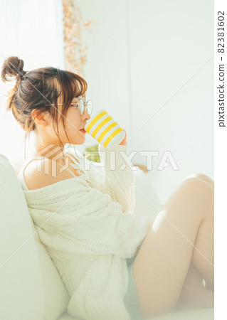 A woman drinking coffee on the sofa A woman drinking coffee on the sofa 82381602