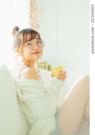 A woman drinking coffee on the sofa 82381603
