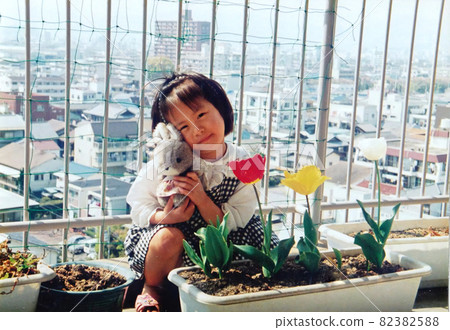 Old film photo: Tulips on the balcony and two sisters Old film photo: Tulips on the balcony and two sisters 82382588