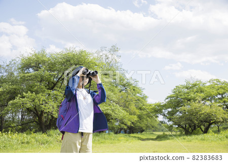 Elementary school girl doing bird watching 82383683