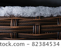 Layer of ice sits on top of textured plastic garden furniture. Macro 82384534