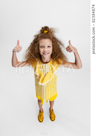 High angle view of little cute curly preschool beautiful girl looking at camera isolated over white studio background. 82384874