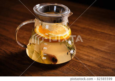 Tea with ginger, lemon, cinnamon in a glass teapot. Tea with ginger, lemon, cinnamon in a glass teapot. 82385599