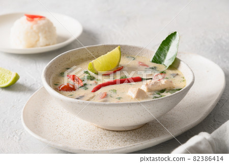 Spicy coconut Tom Kha Gai soup with chicken, cherry tomato. Asian Thai food. Spicy coconut Tom Kha Gai soup with chicken, cherry tomato. Asian Thai food. 82386414