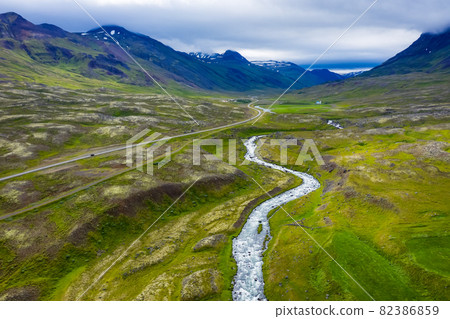 Aerial scenic landscape of Iceland. Remote road and small bridge over blue mountain river. Travel vacation and advanture concept 82386859