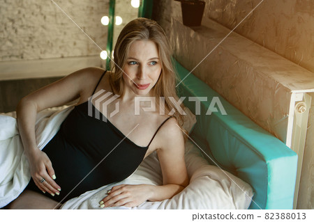 pregnant woman stroking her belly in bed. Home interiors. The concept of healthy digestion, lifestyle, IVF 82388013