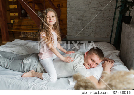 morning family: the children with dad playing in bed. waking up from a dream. I just woke up. love morning family: the children with dad playing in bed. waking up from a dream. I just woke up. love 82388016