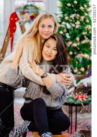 two cheerful friends in the New Year's decorations of the house. same-sex couple 82388157