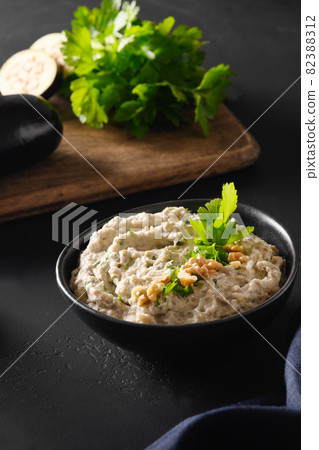 Baba ganoush Levantine cuisine appetizer from baked eggplant with parsley, garlic and olive oil. Close up. Baba ganoush Levantine cuisine appetizer from baked eggplant with parsley, garlic and olive oil. Close up. 82388312