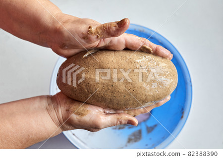 A woman forms a loaf of homemade yeast-free bread for subsequent baking A woman forms a loaf of homemade yeast-free bread for subsequent baking 82388390