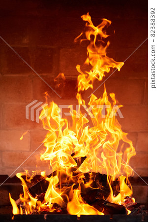 Orange flame from burning firewood in a brick grill. Close-up, selective focus Orange flame from burning firewood in a brick grill. Close-up, selective focus 82388392