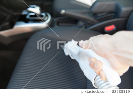 Clean the car seat with a vacuum cleaner. 82388519