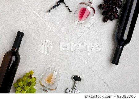 Glasses and bottles of red and white wine on white background from top view Glasses and bottles of red and white wine on white background from top view 82388700